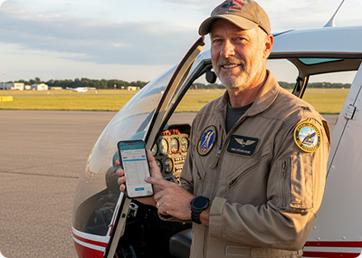 Pilot standing by a light aircraft with PilotApp on his phone